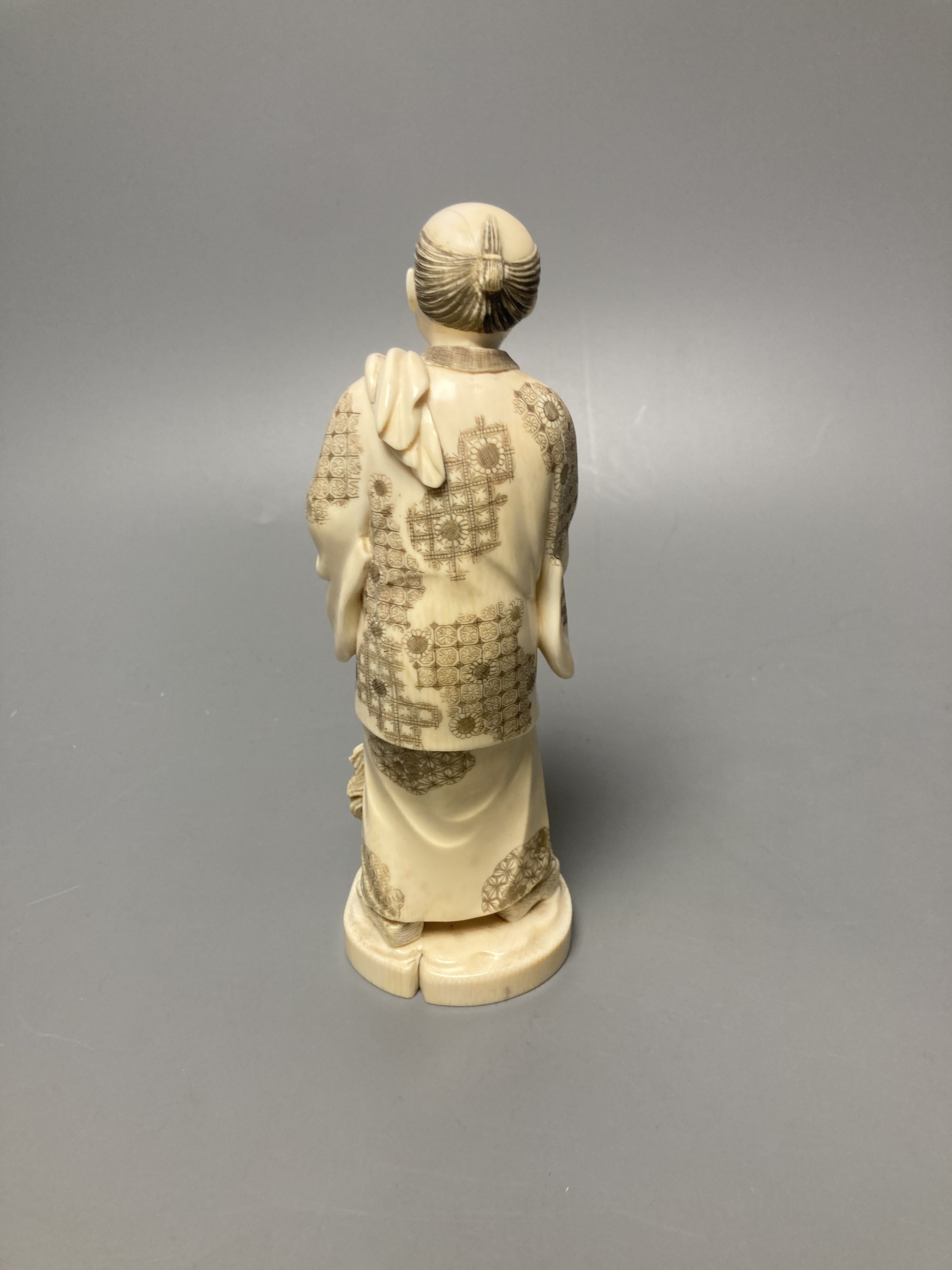 A Japanese ivory okimono of a man and dog, signed tablet to base, early 20th century, 19cm